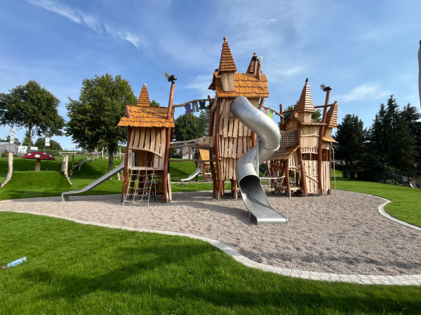 Spielart grosser Spielturm Zwergenstadt Applikationen Themenspielplatz Robinienholz Rohrenrutsche